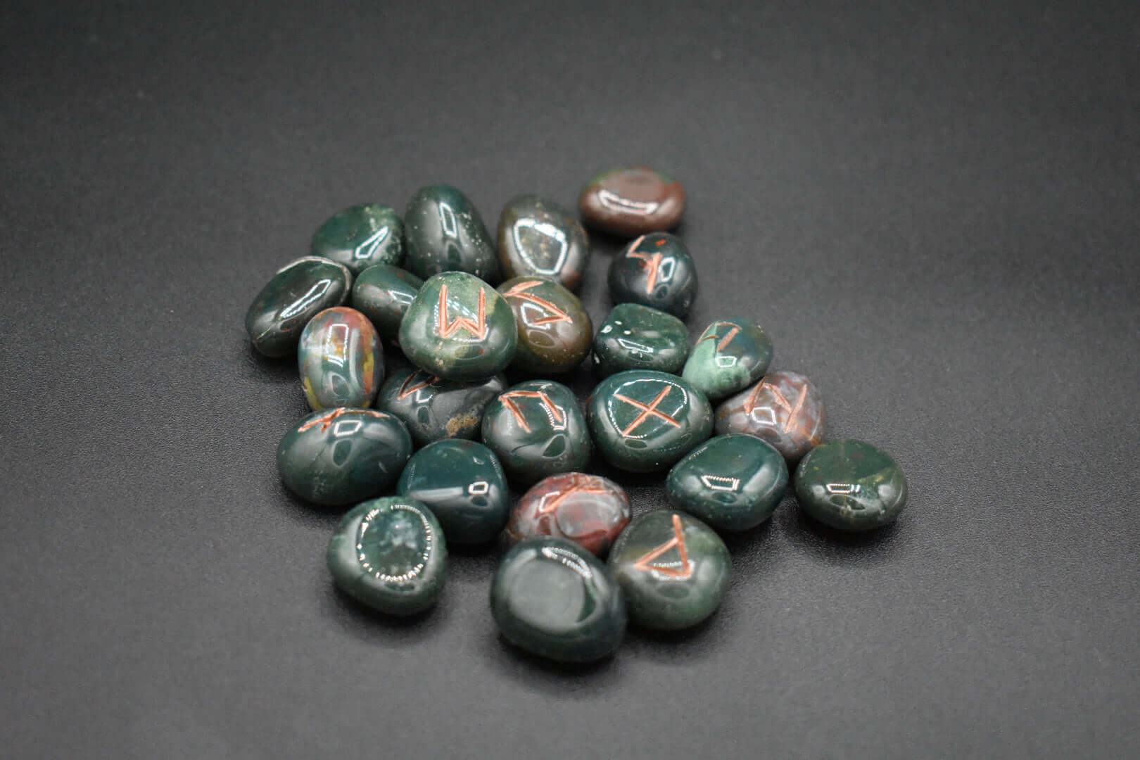 Product photo of bloodstone elder futhark runes with copper inlay