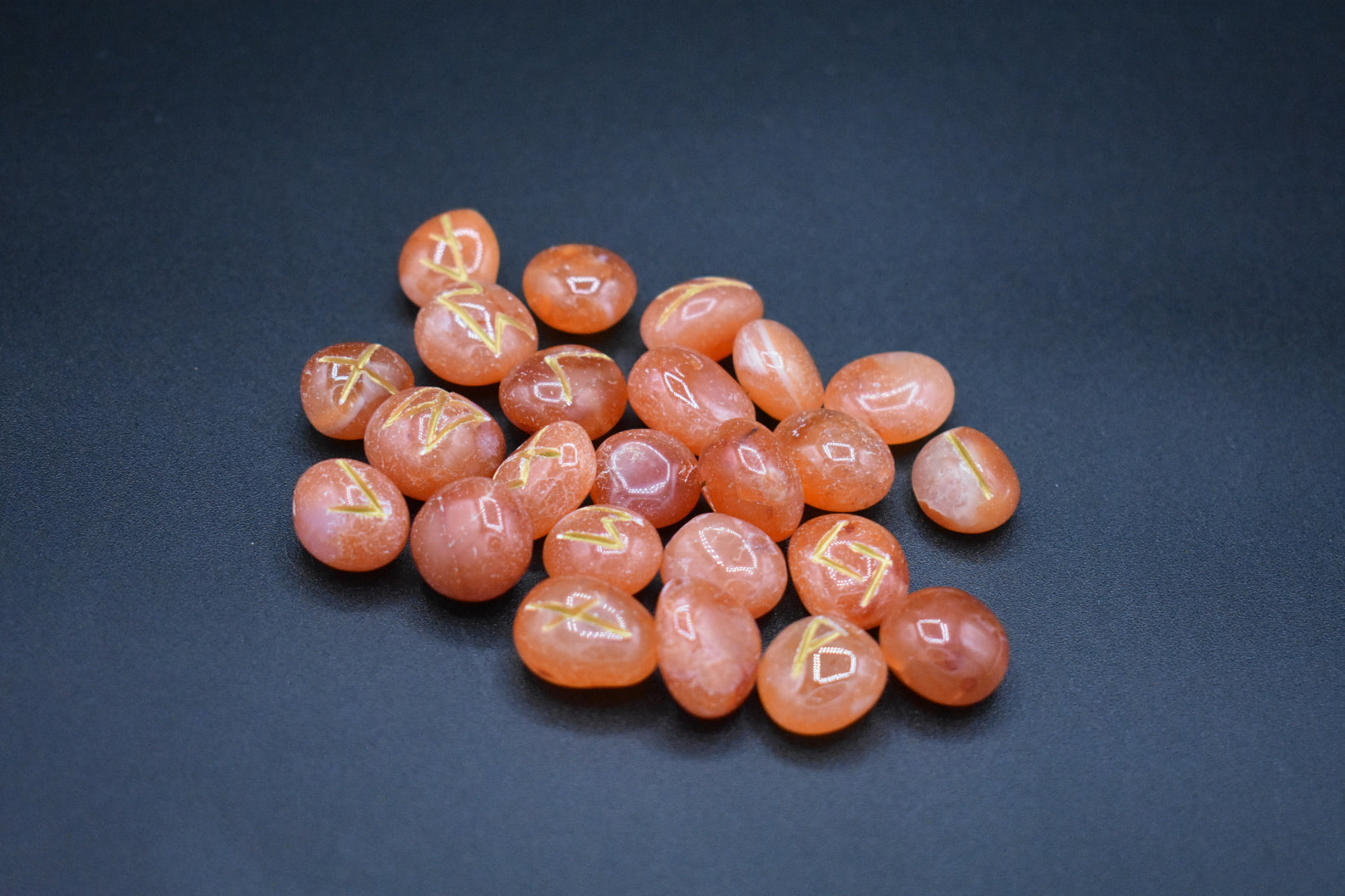 Product photo of carnelian elder futhark runes with gold inlay