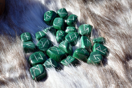 Decorative photo of malachite elder futhark runes on a fur. Picture used as placeholder for rune readings done by Jameson.
