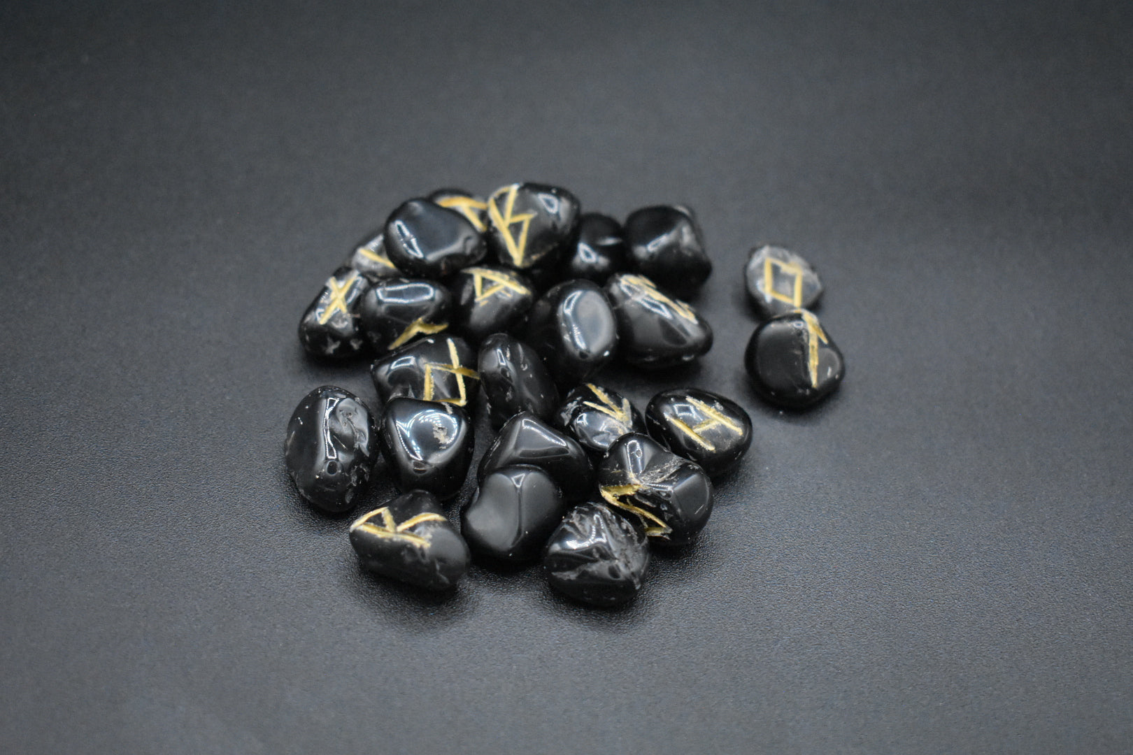 Product photo of onyx elder futhark runes with gold inlay